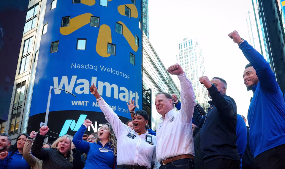 Walmart associates celebrate during the opening bell ceremony at the Nasdaq Market to celebrate the company’s listing transfer, in New York City, U.S., December 9, 2025. REUTERS/Brendan McDermid